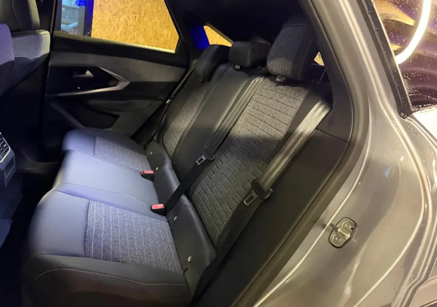 Vue intérieure côté droit des sièges arrière en tissu gris et noir du Peugeot 3008 1.2 HYBRID 136 ALLURE 2025 gris.