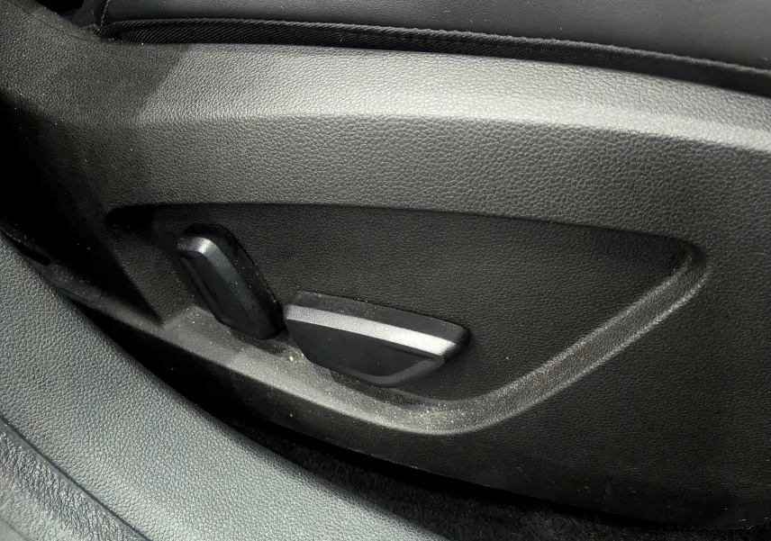 Gros plan sur les commandes électriques de réglage du siège côté gauche, intérieur noir du Renault Symbioz Gris Cassiopé.