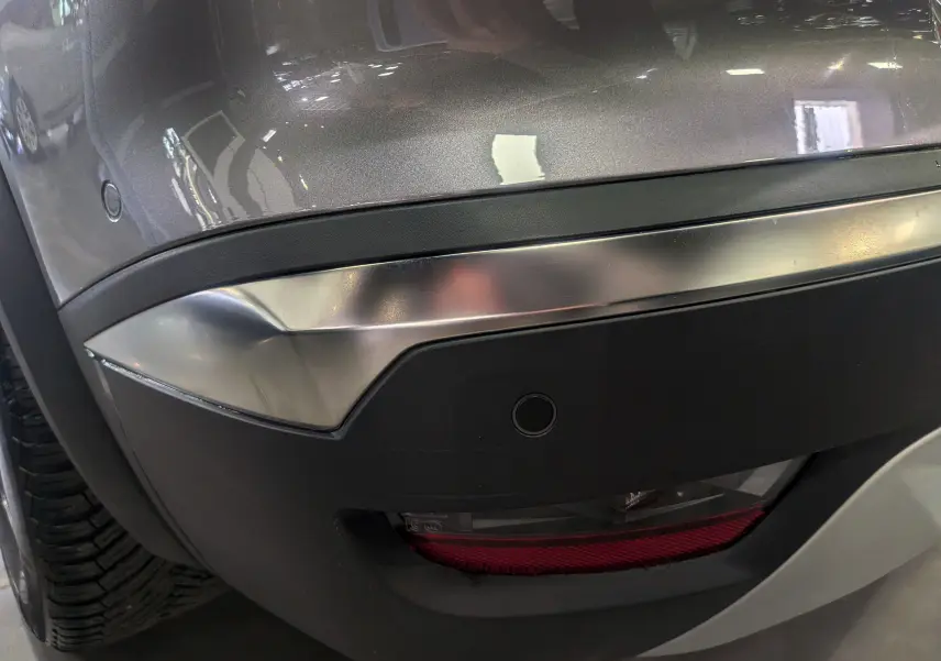 Détail du pare-chocs arrière gris Cassiopé du Renault Symbioz E-TECH, avec capteur de recul et feu antibrouillard.