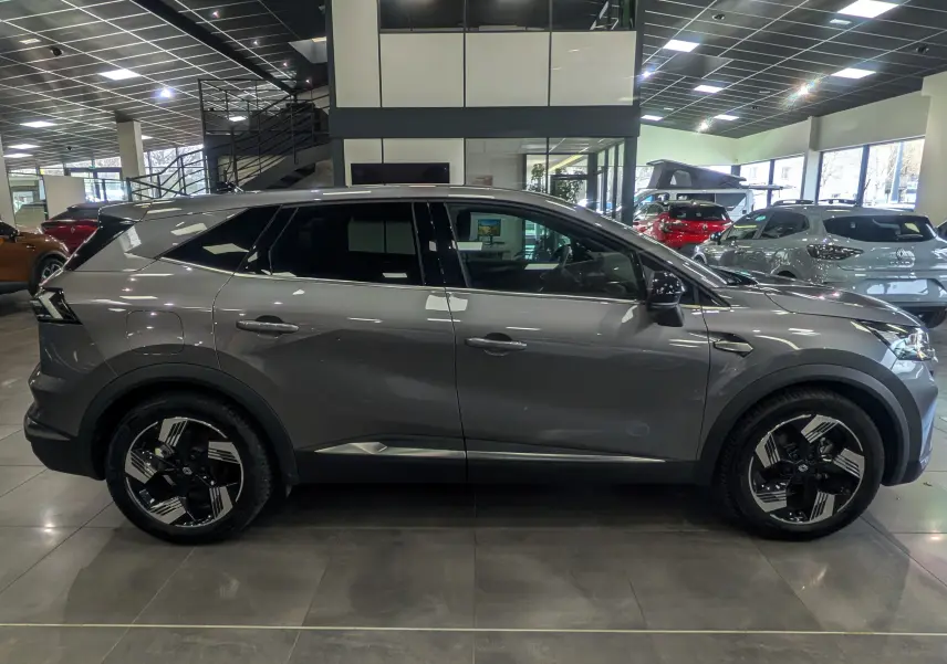 Vue latérale droite du Renault SYMBIOZ E-TECH Full Hybrid gris Cassiopé, soulignant ses jantes bicolores et lignes modernes.