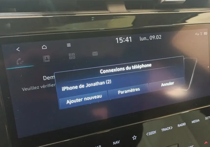 Écran tactile central du Hyundai Tucson gris foncé 2023 affichant la connexion Bluetooth d’un iPhone.