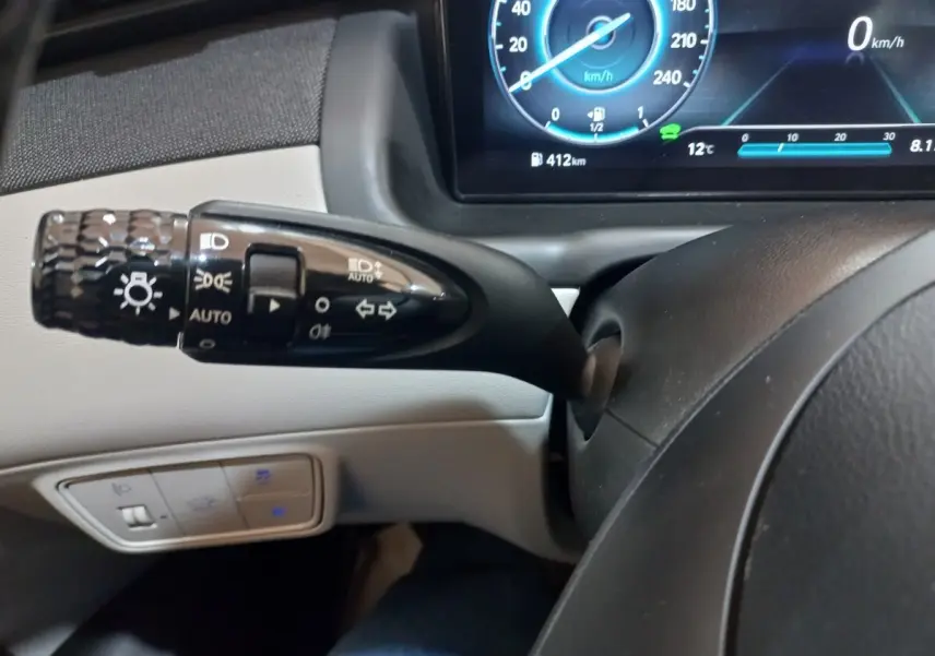 Gros plan sur la commande des phares et clignotants à gauche du volant du Hyundai Tucson gris foncé 2023.