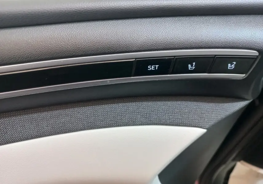 Gros plan sur les boutons de réglage mémoire des sièges sur la porte intérieure d’un Hyundai Tucson gris foncé 2023.