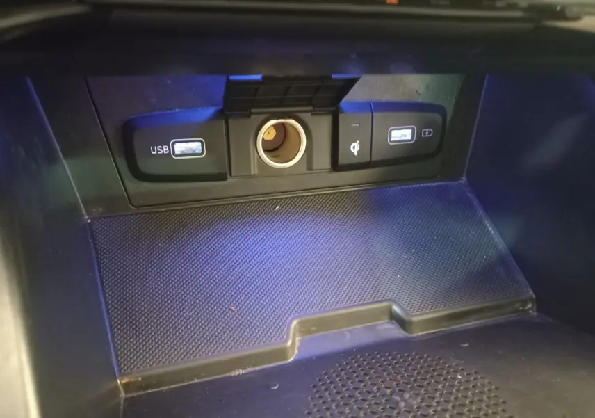 Gros plan sur la zone de recharge avec ports USB et prise 12V du Hyundai Tucson hybride rechargeable 2023.