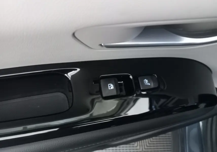 Gros plan sur les commandes de verrouillage et chauffage du siège sur la porte côté conducteur du Hyundai Tucson gris foncé 2023.