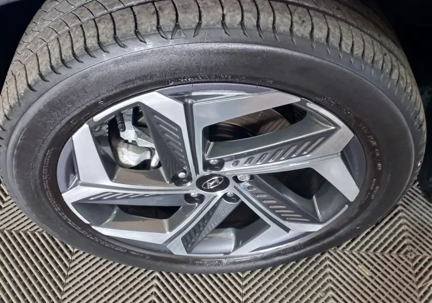 Gros plan sur la roue avant droite du Hyundai Tucson 2023 gris foncé avec jante alliage à cinq branches doubles.