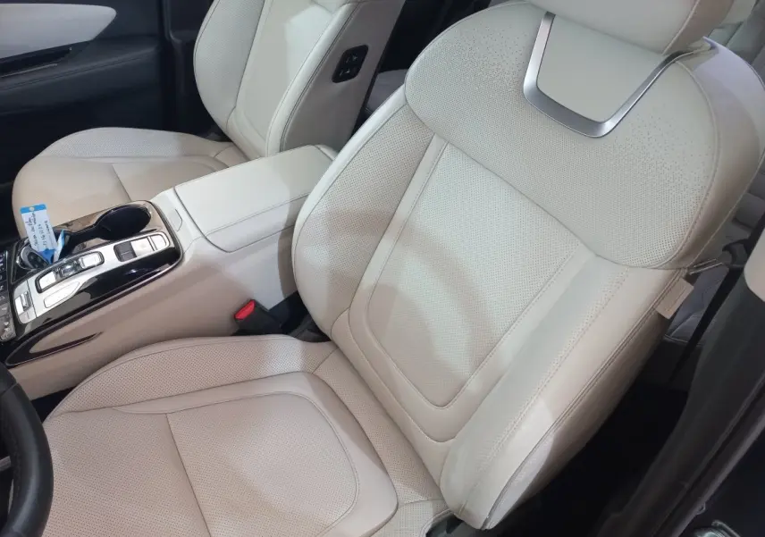 Gros plan sur les sièges avant en cuir beige clair et la console centrale du Hyundai Tucson 1.6 PHEV 265 gris foncé.