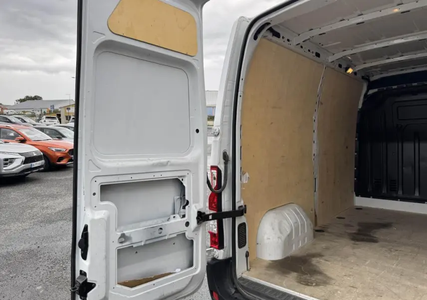 Vue arrière ouverte du Renault Master blanc 2022, mettant en valeur l'intérieur tôlé et le plancher usé de la zone de chargement.