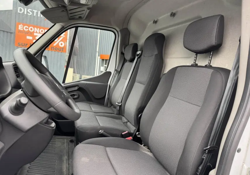Vue intérieure côté conducteur du Renault Master blanc 2022, montrant la banquette 3 places en tissu gris et le volant noir.