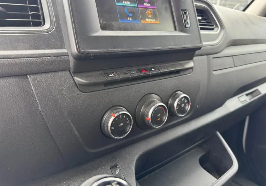 Tableau de bord noir du Renault Master 2022, vue rapprochée sur commandes climatisation et écran tactile central.