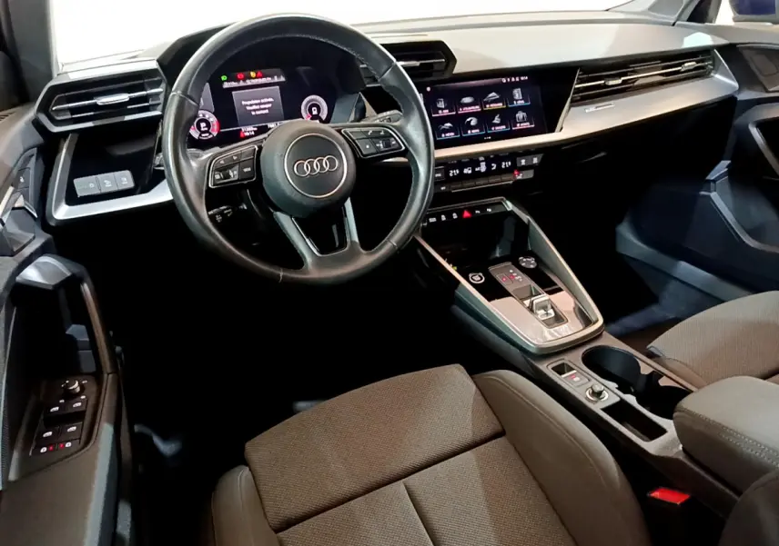 Intérieur Audi A3 35 TFSI 2023 vu côté conducteur, volant cuir, tableau de bord digital et écran tactile central.