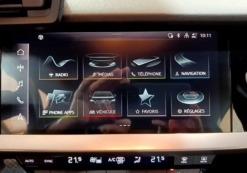 Écran tactile central de l'Audi A3 35 TFSI bleu, affichant le menu multimédia et navigation, vue rapprochée intérieure.