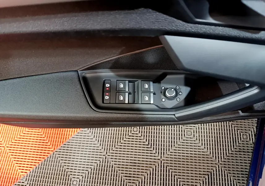 Commande des vitres et rétroviseurs côté conducteur de l'Audi A3 35 TFSI bleu, vue rapprochée intérieure.
