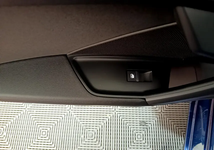 Bouton de verrouillage de porte sur la garniture intérieure côté gauche d'une Audi A3 bleu 2023.