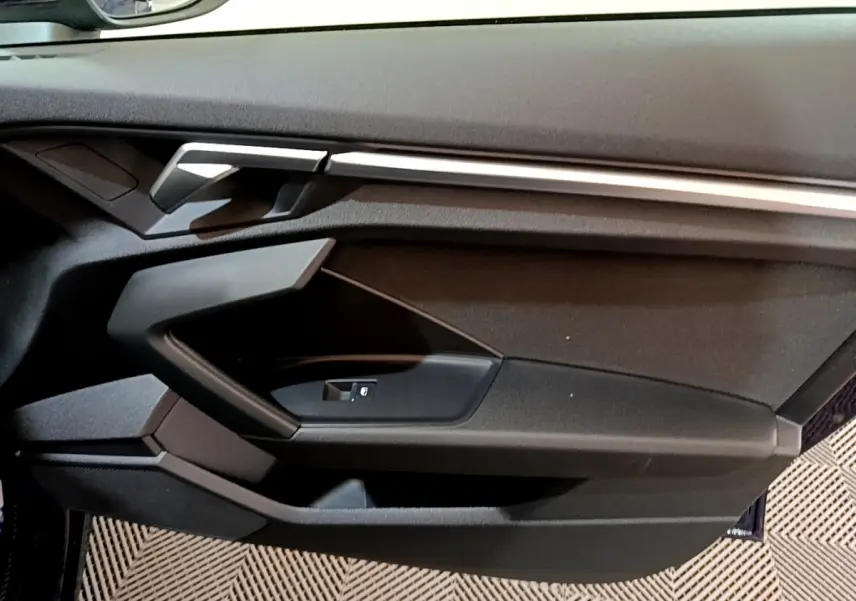 Vue rapprochée de la porte côté gauche de l'Audi A3 35 TFSI 2023 avec garniture noire et insert argenté.