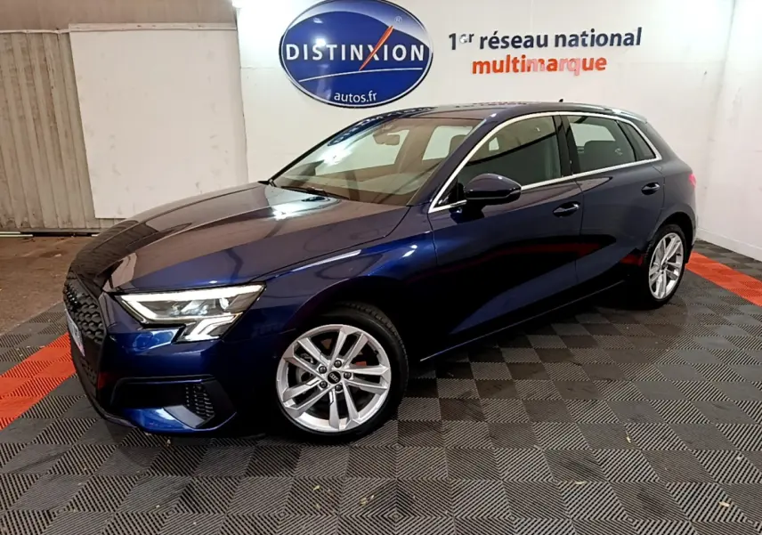 Audi A3 35 TFSI bleu en 3/4 avant droit, avec phares LED et jantes alliage visibles en intérieur showroom