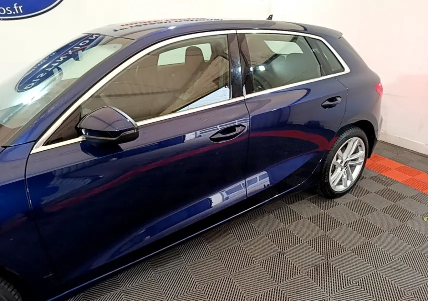 Vue latérale côté gauche d'une Audi A3 bleu profond avec jantes alliage et rétroviseurs assortis.