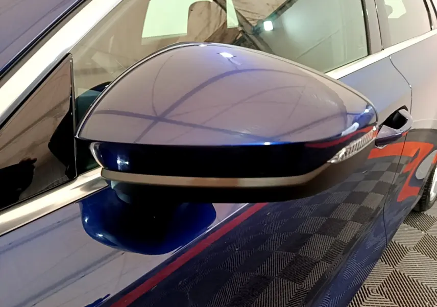 Gros plan sur le rétroviseur droit bleu de l'Audi A3 35 TFSI 150 MHEV 2023 avec clignotant intégré.