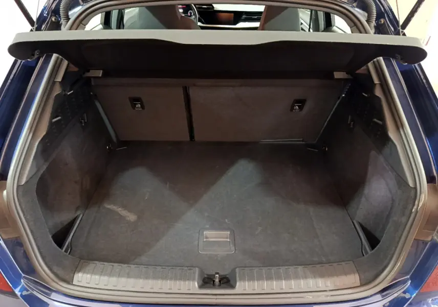 Coffre ouvert vu de l'arrière d'une Audi A3 35 TFSI bleu, montrant l'espace de chargement vide et la tablette de séparation.