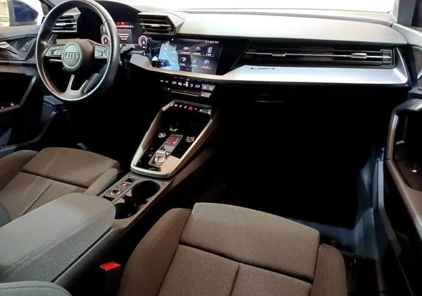Intérieur avant de l'Audi A3 35 TFSI bleu, vue côté conducteur sur tableau de bord et console centrale moderne