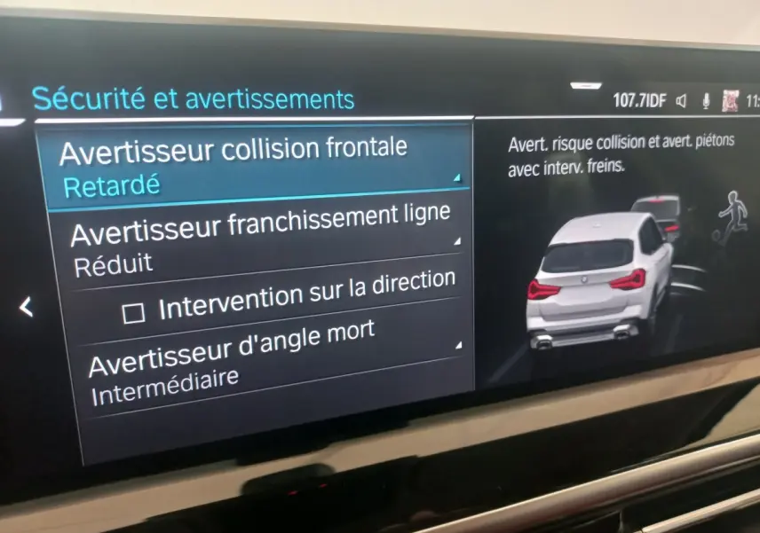 Écran tactile intérieur montrant les alertes de sécurité d’un BMW X3 blanc vu de l’arrière en illustration digitale.