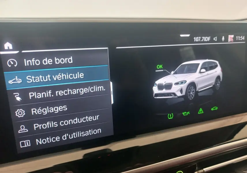 Écran tactile affichant le statut véhicule d'un BMW X3 blanc en vue 3/4 avant droite avec icône OK verte.