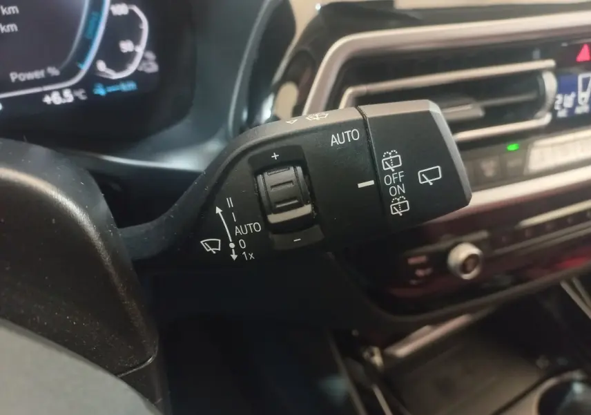Gros plan sur la commande d’essuie-glace côté gauche du tableau de bord d’un BMW X3 blanc hybride rechargeable 2022.
