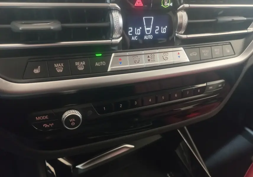 Détail du tableau de bord noir avec commandes climatisation et multimédia du BMW X3 xDrive30e blanc 2022.