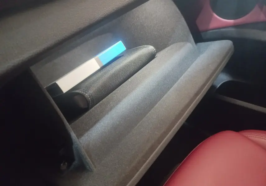 Gant de boîte à gants ouvert côté passager intérieur d'une BMW X3 xDrive30e 2022 avec siège en cuir rouge visible.