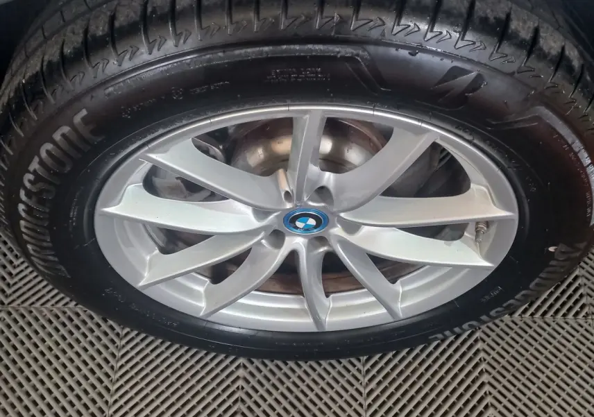 Gros plan sur la jante alliage argentée avec logo BMW au centre, montée sur pneu Bridgestone.