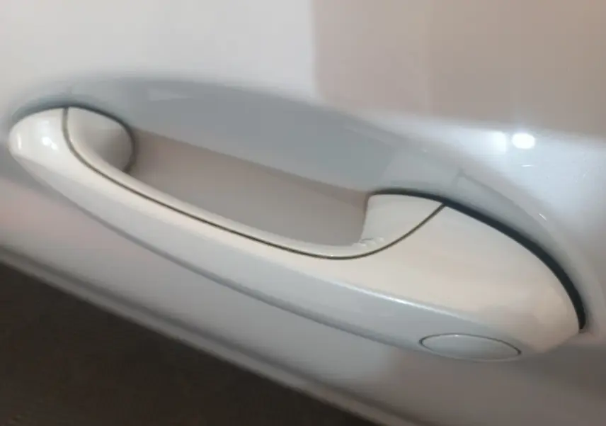 Poignée de porte blanche en gros plan sur BMW X3 xDrive30e 2022, finition Business Design.