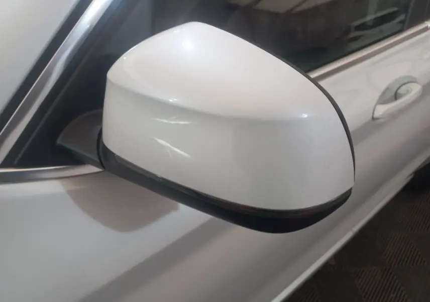 Gros plan sur le rétroviseur droit blanc du BMW X3 xDrive30e 2022, avec la portière et poignée visibles en arrière-plan.