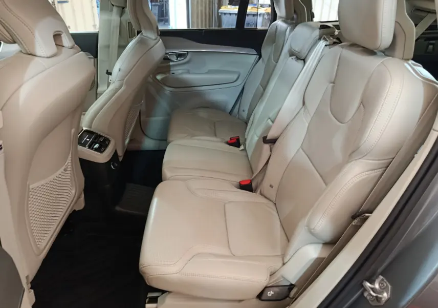 Vue côté droit de la banquette arrière cuir beige du Volvo XC90 gris clair avec appuie-têtes et ceinture de sécurité.