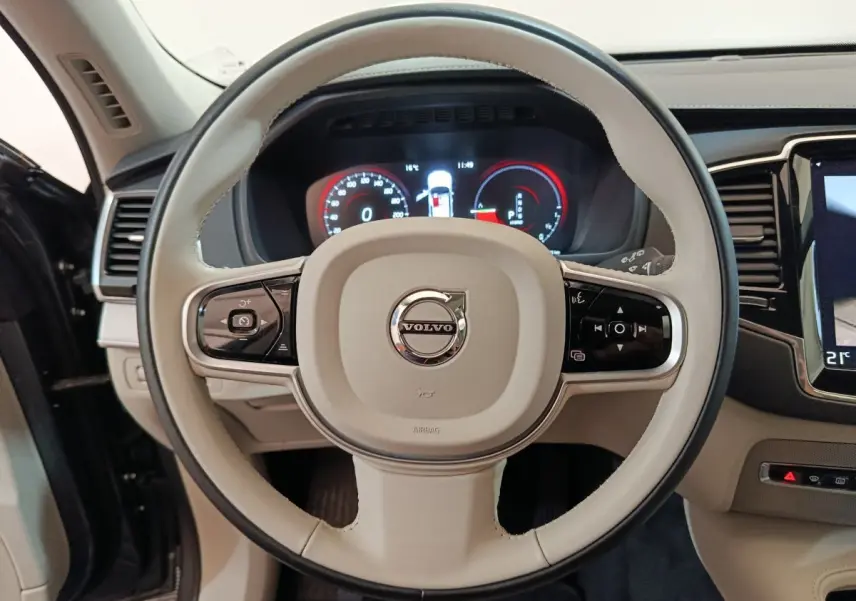 Volant beige du Volvo XC90 T8 2019 avec commandes multifonctions et tableau de bord numérique visible.