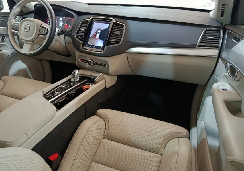 Intérieur beige clair du Volvo XC90 T8, vue côté passager avec console centrale et écran tactile en évidence.