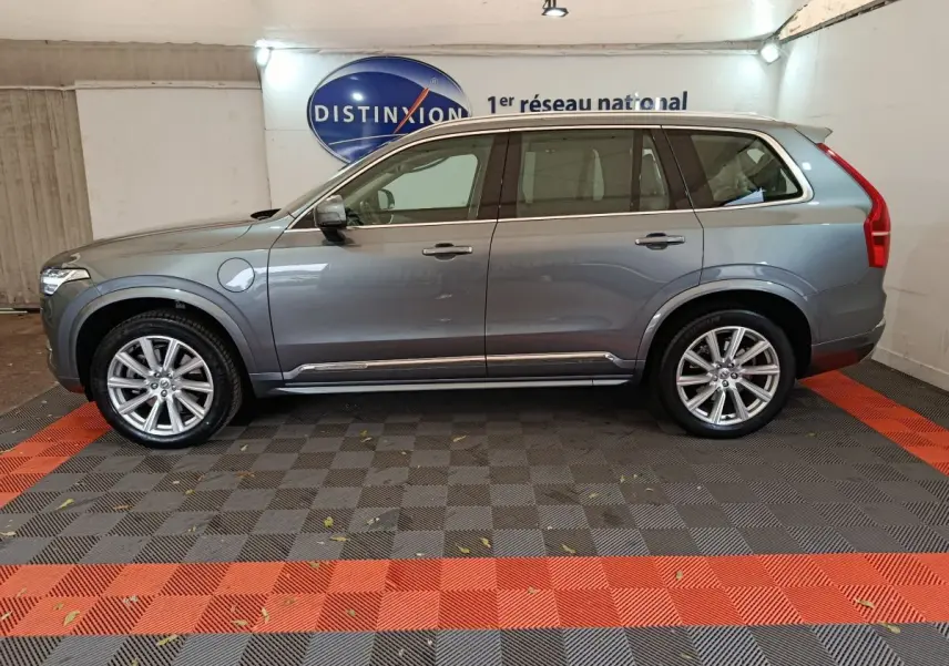 Profil côté gauche du Volvo XC90 gris clair hybride rechargeable, avec jantes alliage et toit ouvrant en verre visible.