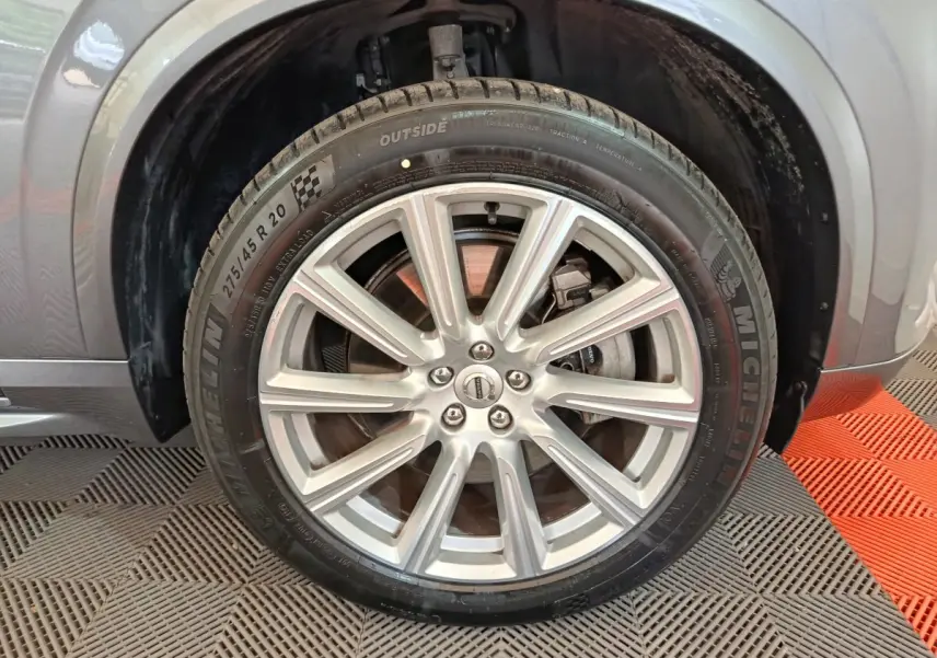 Gros plan sur la roue avant droite du Volvo XC90 gris clair, mettant en valeur la jante alliage et le pneu Michelin.