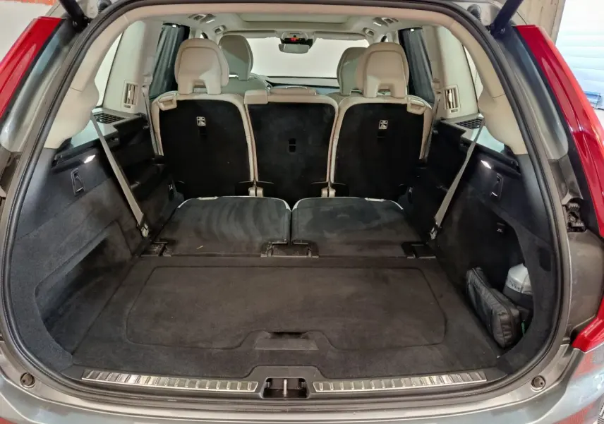 Coffre ouvert du Volvo XC90 gris clair, montrant la 3ème rangée de sièges rabattus et plancher plat.