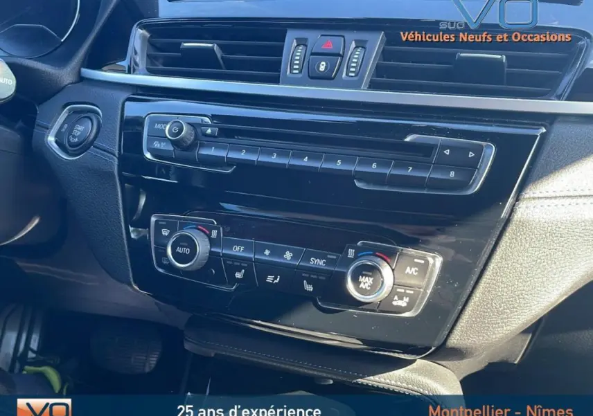 Tableau de bord noir brillant de BMW X2 F39 M35i 2019, avec commandes climatisation et démarrage sans clé visibles.