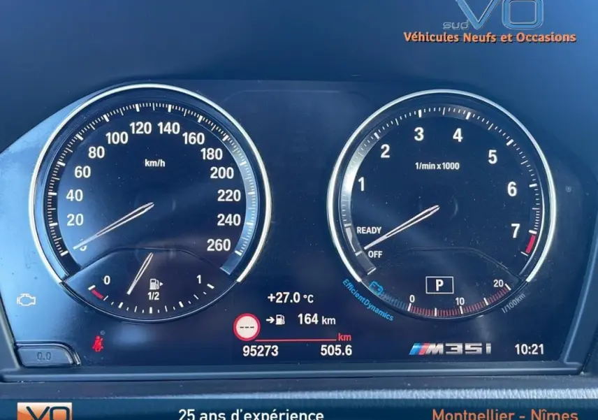 Gros plan sur le tableau de bord numérique gris du BMW X2 M35i 2019, affichant vitesse, compte-tours et informations de conduite.