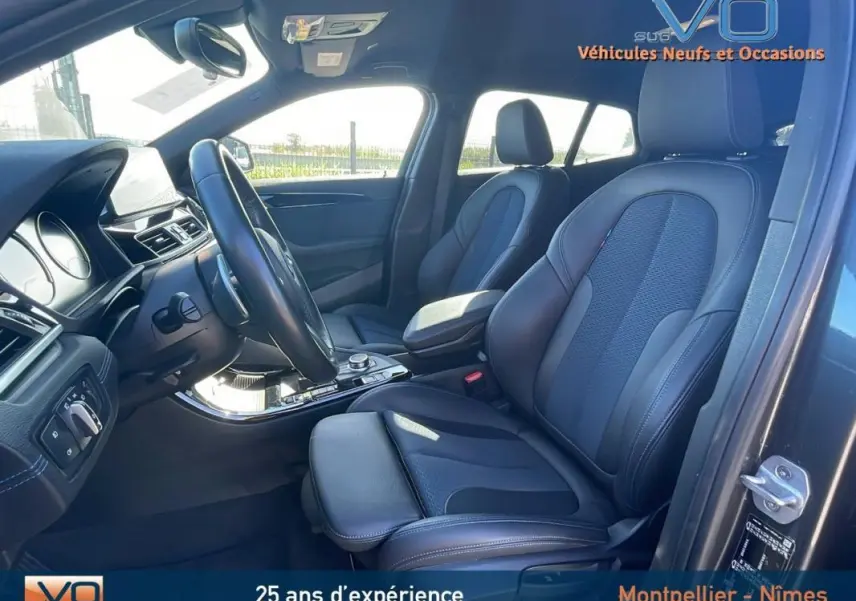 Intérieur avant du BMW X2 F39 M35i 2019 avec sièges en cuir noirs, accoudoir central et volant multifonction.