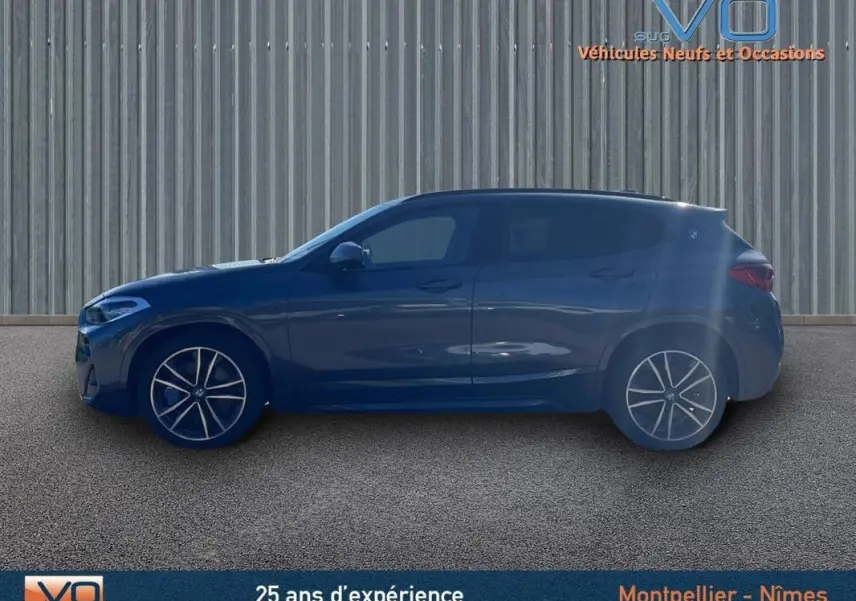 Profil côté gauche d'un BMW X2 F39 M35i gris avec jantes alliage 19 pouces sur fond industriel.