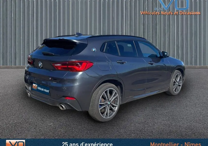 BMW X2 F39 M35i gris en 3/4 arrière droit, mettant en valeur ses jantes alliage 19 pouces et ses feux arrière LED.