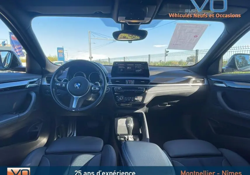 Intérieur avant de la BMW X2 F39 M35i 2019, vue du poste de conduite avec volant multifonction et écran central.