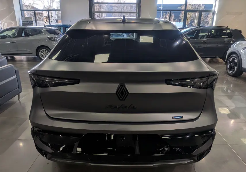 Vue arrière d'un Renault Rafale gris schiste satin avec logo central et feux arrière effilés en intérieur showroom.