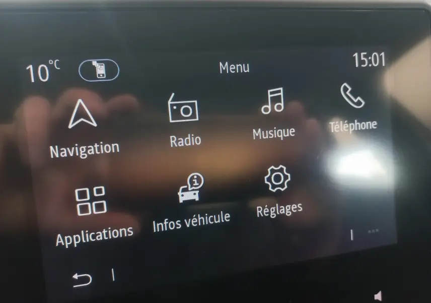 Écran tactile du système multimédia de la Renault Clio blanc, affichant menu navigation, radio, musique et téléphone.