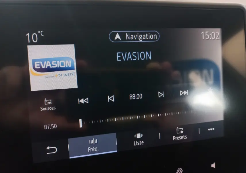 Écran tactile central de la Renault Clio blanc 2020 montrant la radio FM sur la fréquence 88.00 MHz à 15h02.