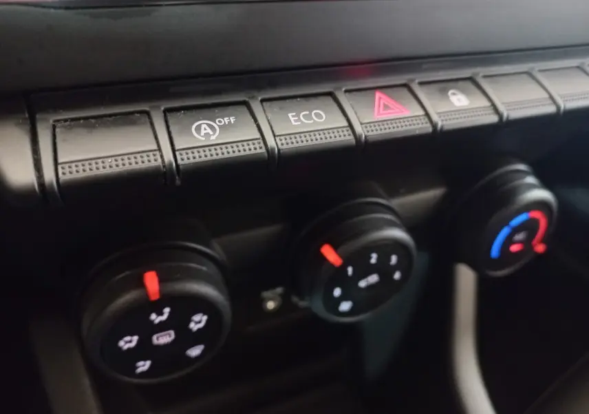 Gros plan sur les commandes de climatisation et boutons fonctionnels du tableau de bord de la Renault Clio Air Nav Blue dCi 85 blanche.