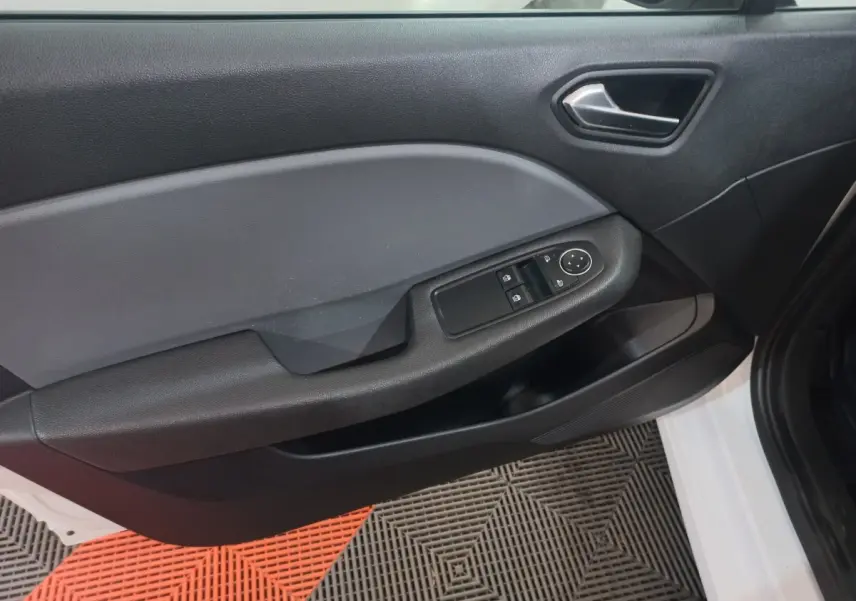 Vue rapprochée de la porte avant gauche blanche d'une Renault Clio 2020 avec commandes électriques des vitres.