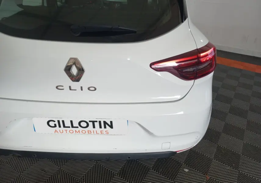 Vue arrière droite d'une Renault Clio blanche de 2020 avec feux arrière LED et logo Renault visible.